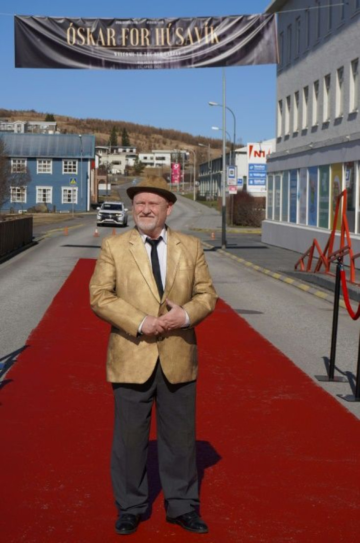 Icelandic actor Sigurdur Illugason posing on the main Husavik street painted in red, so residents can also experience the feeling of walking the red carpet