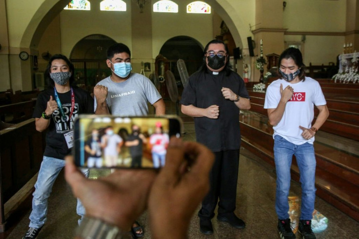 TikTok is playing a central role in Father Paul Woo's (2nd R) efforts to coax the young into church pews in Navotas City, one of the poorest areas of the Philippines' capital