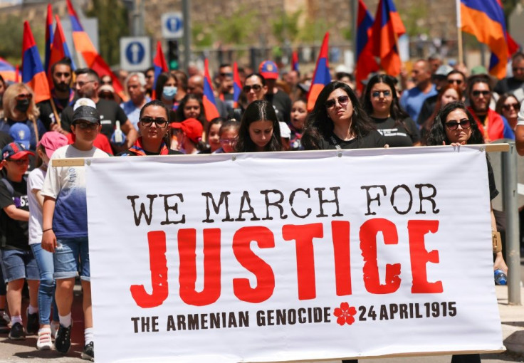 Armenians carry national flags and a large banner during a march in Jerusalem to commemorate the anniversary of mass killings by Ottoman Turkey