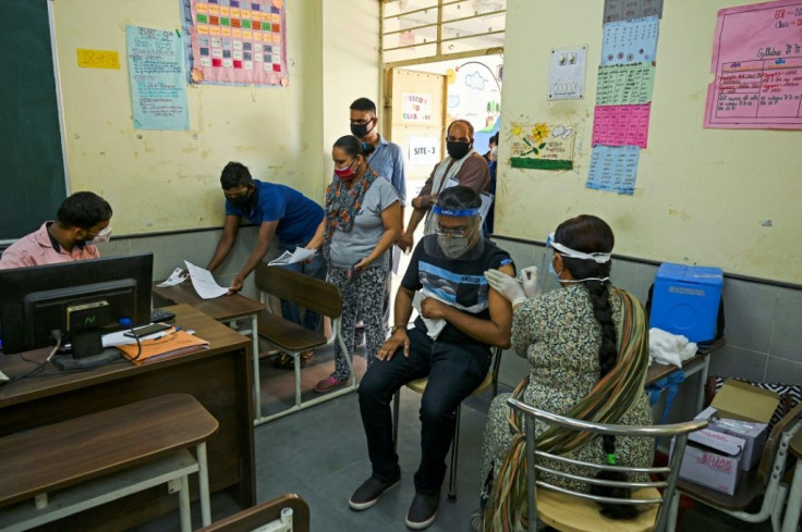 A health worker inoculates a man with a dose of the Covaxin Covid-19 coronavirus vaccine in a school-turned-vaccination centre in New Delhi