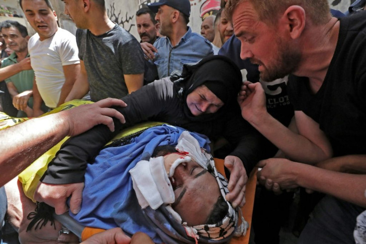 Relatives of Palestinian Hussein al-Titi, 26, killed by Israeli gunfire in Fawwar refugee camp near the city of Hebron, in the occupied West Bank, mourn over his body