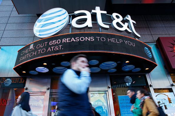 People walk past an AT&T store in New York, Oct. 23, 2016.