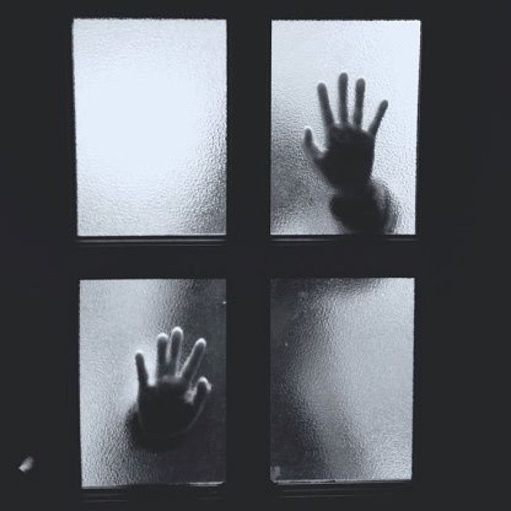 Above is a representative image of hands against a closed door.