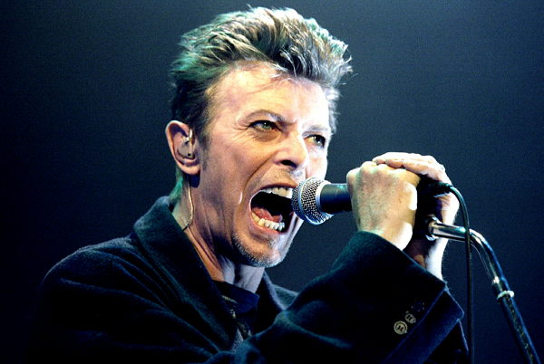 British pop star David Bowie screams into the microphone as he performs on stage during his concert in Vienna, Feb. 4, 1996.