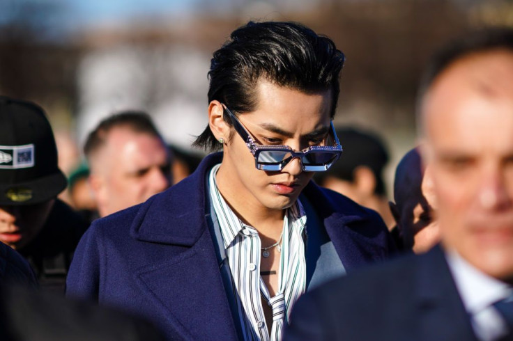 PARIS, FRANCE - JANUARY 16: Actor Kris Wu wears Louis Vuitton sunglasses, silver earrings and necklace, a white and blue striped shirt and tie set, an oversized gray blue blazer jacket, a long oversized purple wool coat, outside Vuitton, during Paris Fash
