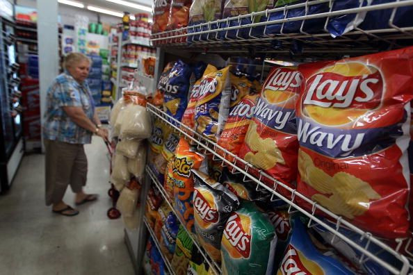 Frito-Lay has recalled its Smartfood Delight Sea Salt Flavored popcorn due to a milk allergy. Consumers that purchased the contaminated popcorn will receive a full refund. A woman walks past bags of chips manufactured by PepsiCo Frito-Lay brand on a shelf