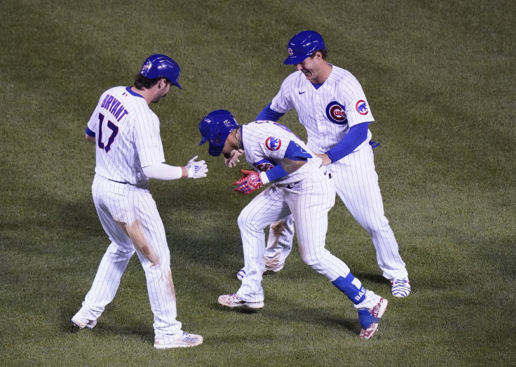 Javier Baez #9 of the Chicago Cubs celebrates with Anthony Rizzo #44 and Kris Bryant #17 following his RBI during the tenth inning of a game against the Cleveland Indians at Wrigley Field on September 16, 2020 in Chicago, Illinois.