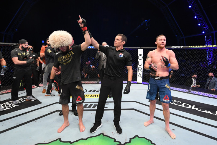 In this handout image provided by UFC, (L-R) Khabib Nurmagomedov of Russia celebrates his victory over Justin Gaethje in their lightweight title bout during the UFC 254 event