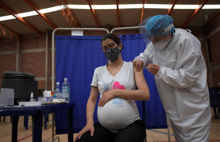 A pregnant woman receives a dose of the Pfizer-BioNTech vaccine against COVID-19 at a vaccination center in Bogota, on July 23, 2021. - Colombia started to inoculate pregnant women who have three months of gestation or more.