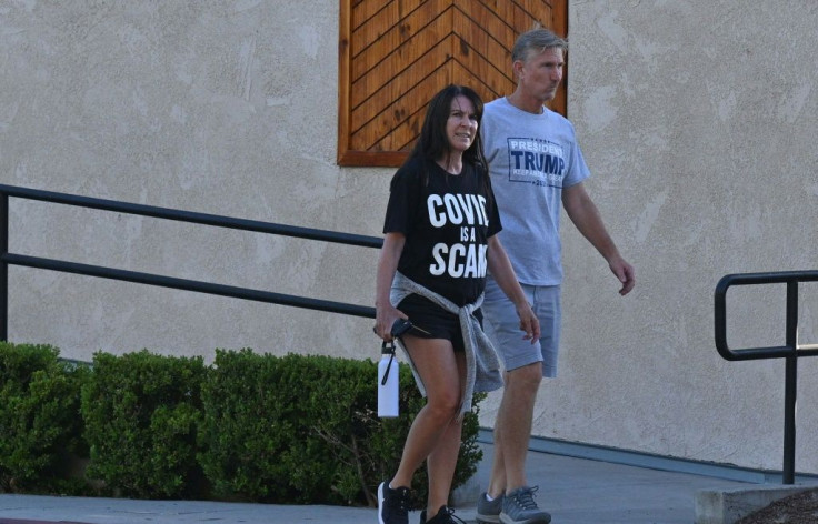 A couple walks outside Old World Huntington Beach in California where Sherri Tenpenny, an osteopath from Ohio and anti-vaccine advocate, spoke on August 5, 2021