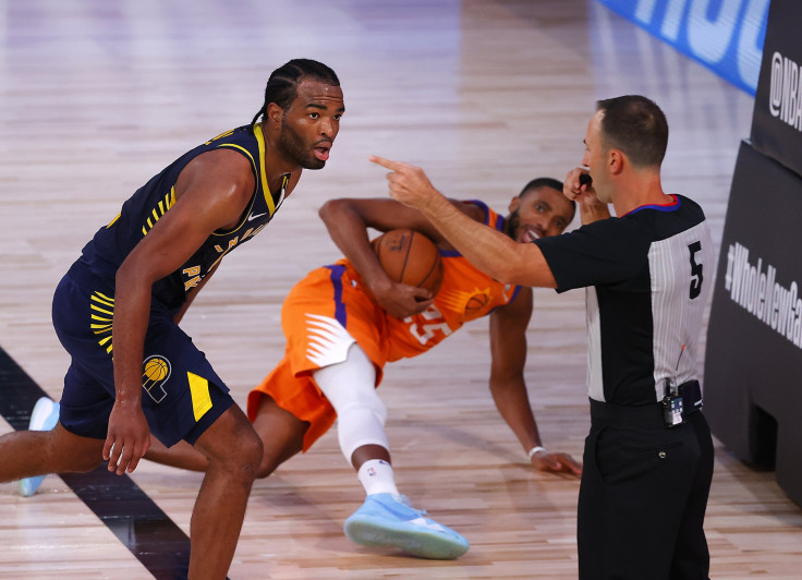 Referee Kane Fitzgerald #5 calls a foul as T.J. Warren #1 of the Indiana Pacers and Mikal Bridges #25 of the Phoenix Suns