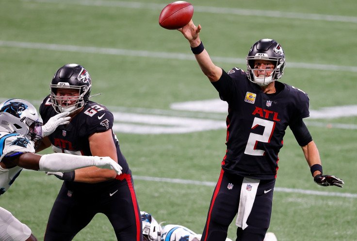Matt Ryan #2 of the Atlanta Falcons attempts to dump the ball off as he is pressured in the pocket by the Carolina Panthers during the second half at Mercedes-Benz Stadium on October 11, 2020 in Atlanta, Georgia. 