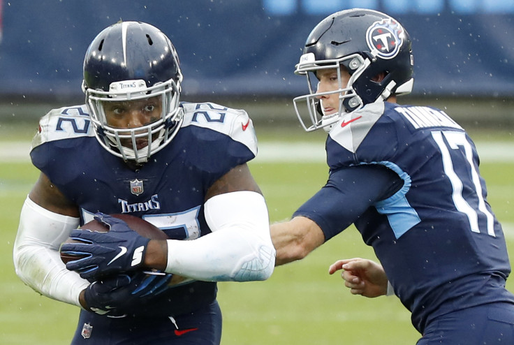 Running back Derrick Henry #22 of the Tennessee Titans takes the hand-off from quarterback Ryan Tannehill #17 and runs with the ball in the first quarter against the Houston Texans at Nissan Stadium on October 18, 2020 in Nashville, Tennessee.