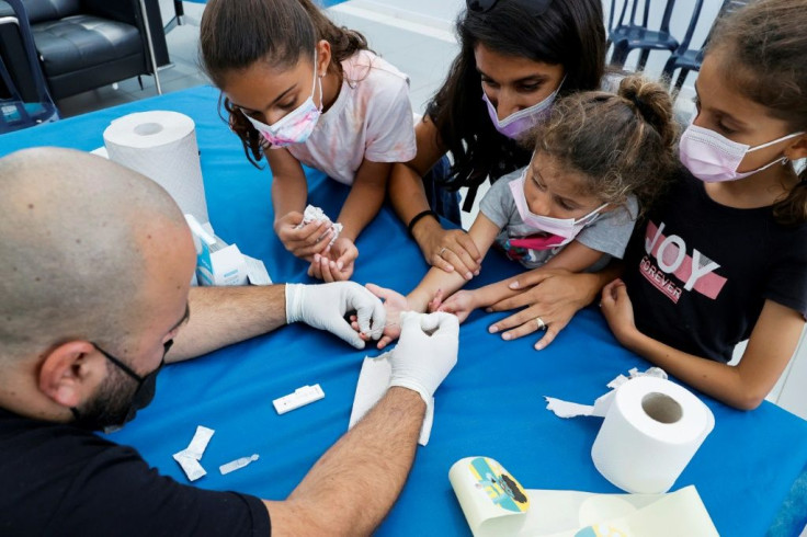 A 12-year-old in New Jersey passed away within a few days after testing positive of COVID-19. In photo: a health worker gets a blood sample from a child.