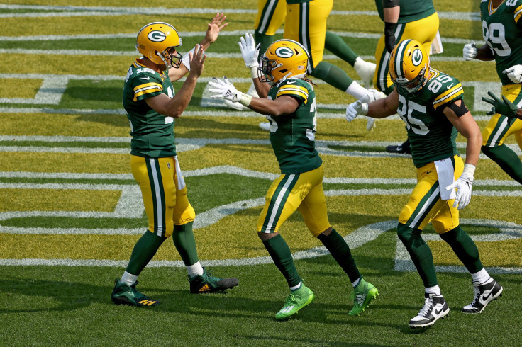 Aaron Rodgers #12 and Aaron Jones #33 of the Green Bay Packers celebrate after Jones scored a touchdown in the third quarter against the Detroit Lions at Lambeau Field on September 20, 2020 in Green Bay, Wisconsin. 