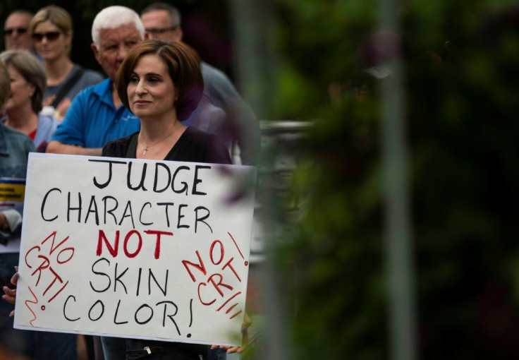 A Texas high school principal was forced to resign this week following allegations that he was indoctrinating students with CRT. In photo: a woman holds up a sign at a rally against teaching "critical race theory" in schools, in Leesburg, Virginia on June