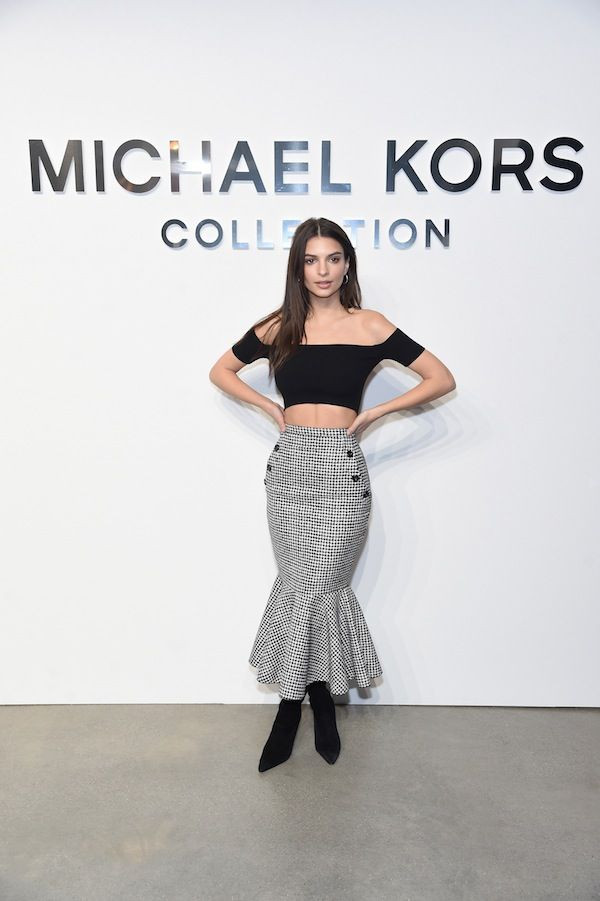 Before sitting front row at the Michael Kors Fall 2017 runway show, Emily Ratajkowski posed for photographers in the designer's Pre-Fall 2017 black off-the-shoulder crop top and houndtooth pencil skirt with flare bottom.