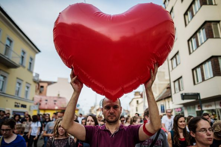 Pictured: A man is holding a heart-shaped balloon.