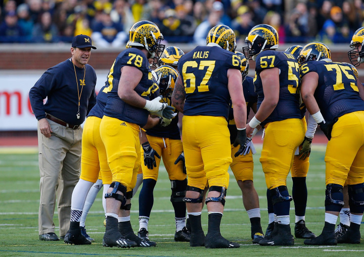 Head coach Jim Harbaugh of the Michigan Wolverines listens in on a huddle during the Michigan Football Spring Game on April 1, 2016 at Michigan Stadium in Ann Arbor, Michigan.
