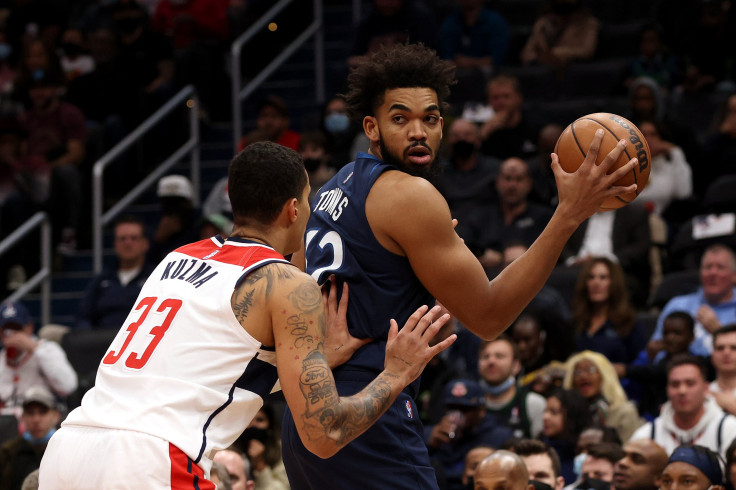 DECEMBER 01: Karl-Anthony Towns #32 of the Minnesota Timberwolves looks to pass against Kyle Kuzma #33 of the Washington Wizards in the first half at Capital One Arena on December 01, 2021 in Washington, DC.
