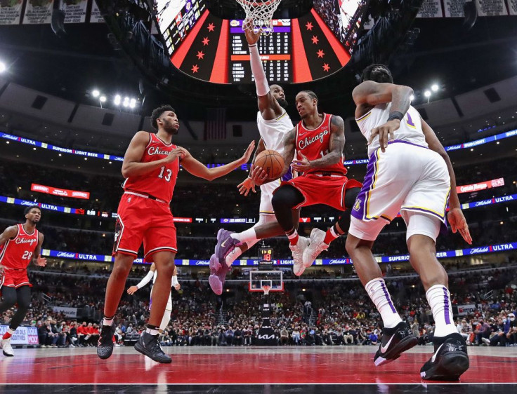  DeMar DeRozan #11 of the Chicago Bulls passes to teammate Tony Bradley #13 under pressure from LeBron James #6 (rear) and DeAndre Jordan #10 of the Los Angeles Lakers 