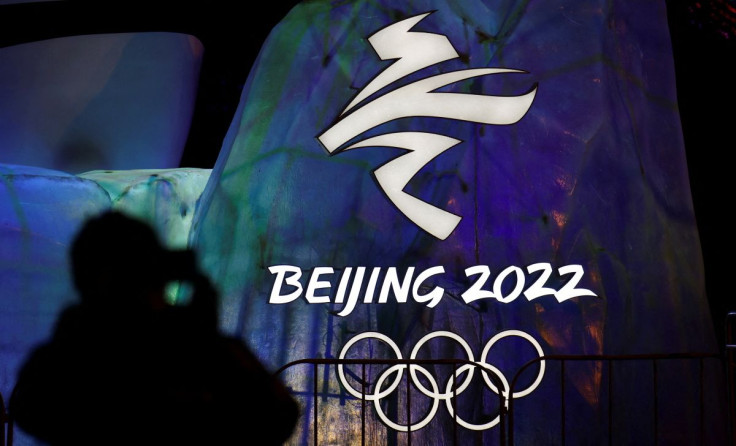 A man photographs an illuminated logo ahead of the Beijing 2022 Winter Olympics in Beijing, China January 26, 2022.
