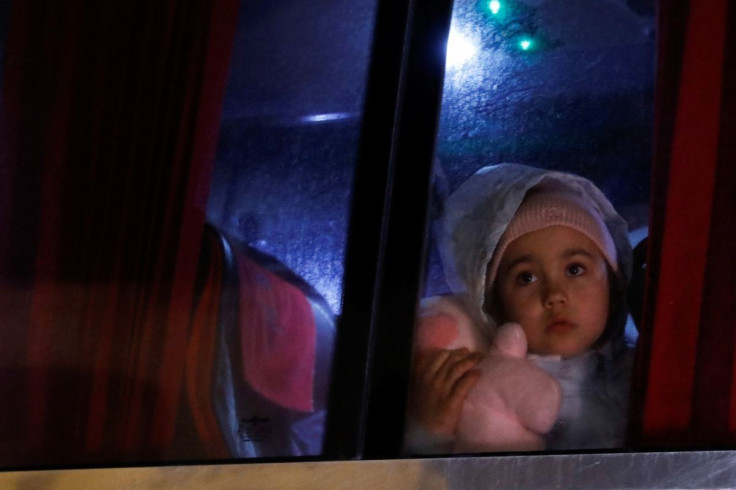 A girl looks through a bus window as she arrives in Athens, after fleeing Russia's military operation against Ukraine, in Athens, Greece, March 1, 2022.