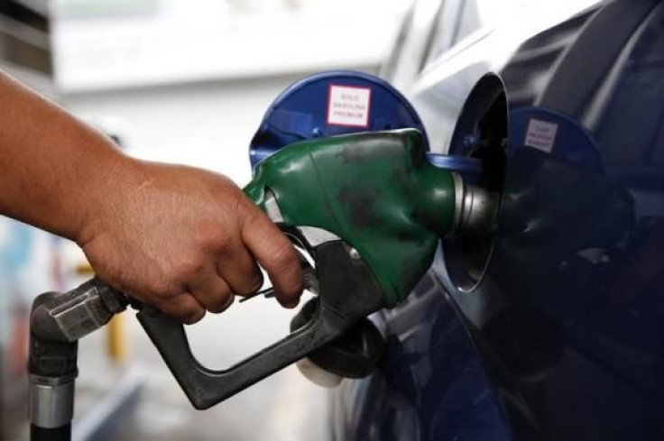 An employee pumps gas into a car at a gas station of the state oil company PDVSA in Caracas Dec. 16, 2013.