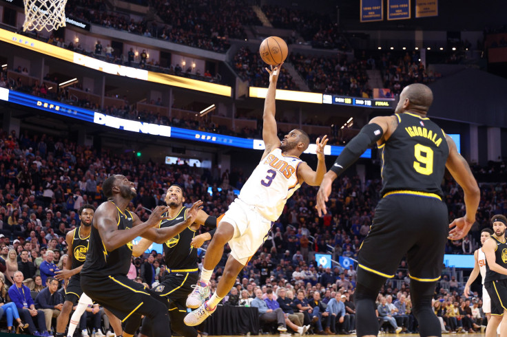 Chris Paul #3 of the Phoenix Suns shoots over Draymond Green #23 of the Golden State Warriors in the final minute of their game at Chase Center on March 30, 2022 in San Francisco, California.