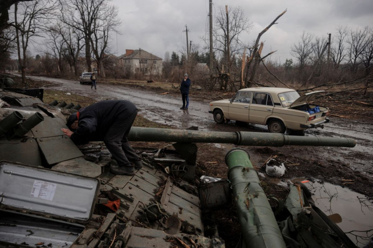 A local man looks into a Russian tank left behind after Ukrainian forces expelled Russian soldiers from the town of Trostyanets which they had occupied at the beginning of its war with Ukraine, March 30, 2022.