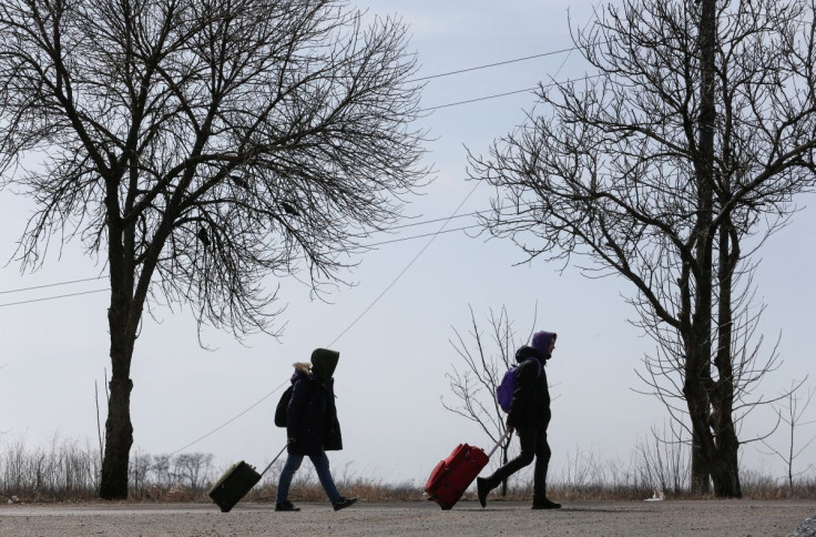 Refugees walk along a road as they leave the city during Ukraine-Russia conflict in the besieged southern port of Mariupol, Ukraine March 20, 2022.