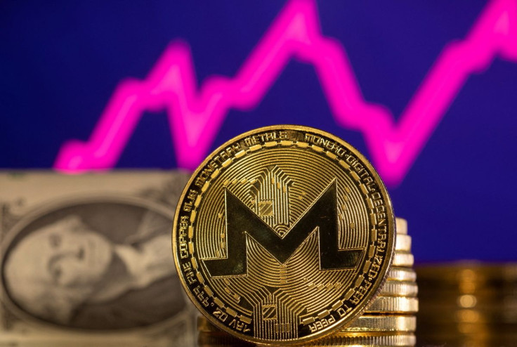 A representations of cryptocurrency Monero is seen in front of a stock graph and U.S. dollar in this illustration taken, January 24, 2022.