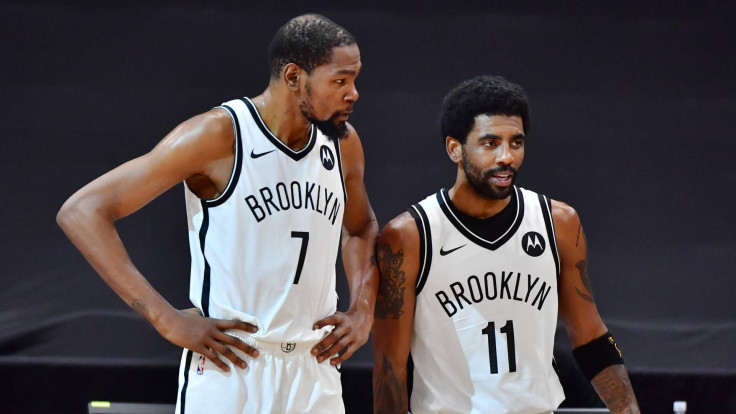 Kevin Durant (L) and Kyrie Irving (R) of the Brooklyn Nets converse during a game against the Toronto Raptors at Amalie Arena on April 27, 2021.