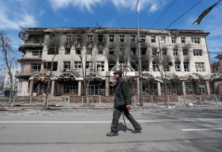 A resident walks near a building destroyed in the course of the Ukraine-Russia conflict, in the southern port city of Mariupol, Ukraine April 10, 2022.