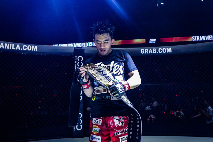 Joshua Pacio holding his ONE Strawweight championship belt.