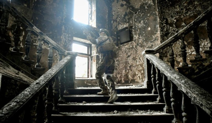 Russian soldiers patrol in the bombed Mariupol theatre during a media tour organised by Russia