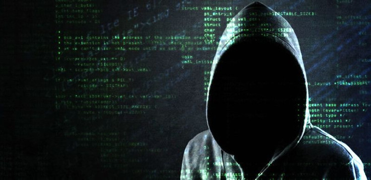 Hooded shadowy figure in front of code