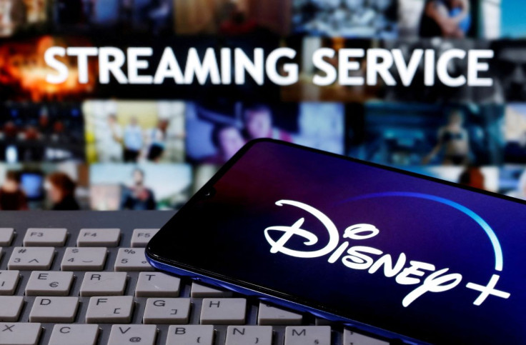 A smartphone with displayed "Disney" logo is seen on the keyboard in front of displayed "Streaming service" words in this illustration taken March 24, 2020.