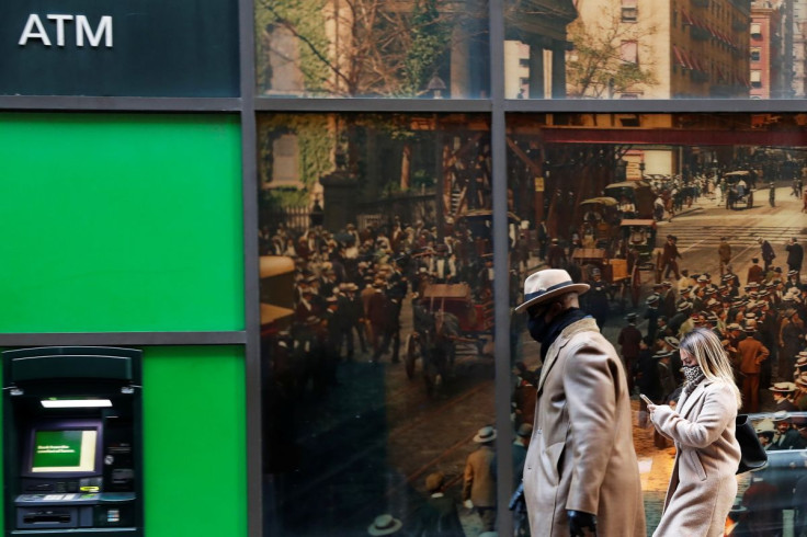 People wearing protective face masks walk, as the global outbreak of the coronavirus disease (COVID-19) continues, in the financial district of New York, U.S., November 19, 2020. 