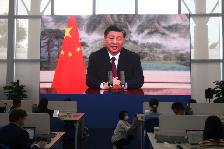 Representation. A screen shows Chinese President Xi Jinping speaking at a meeting.