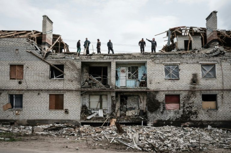 Workers clear rubble from a building destroyed by Russian shelling in Cherkaske, eastern Ukraine