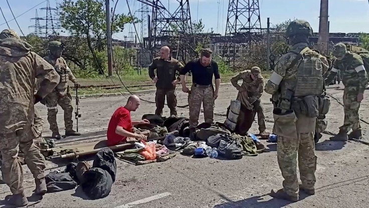 Service members of Ukrainian forces who have surrendered after weeks holed up at Azovstal steel works are being searched in Mariupol.