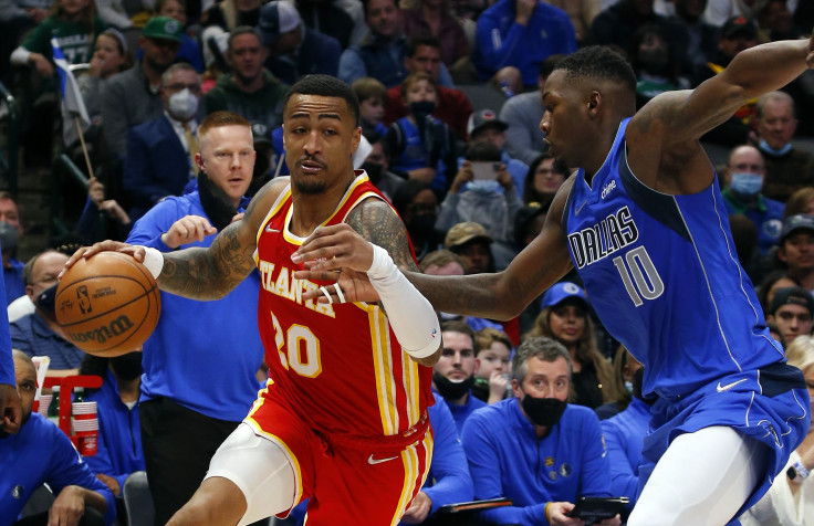 John Collins #20 of the Atlanta Hawks tries to drive the ball past Dorian Finney-Smith #10 of the Dallas Mavericks at American Airlines Center on February 06, 2022 in Dallas, Texas.