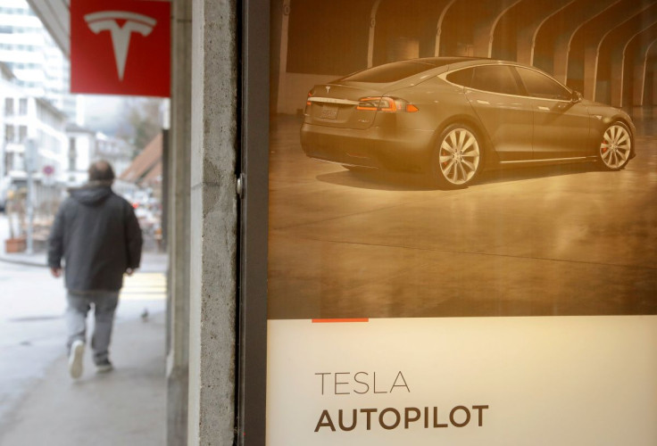 Tesla just cut about 200 jobs under its Autopilot unit - a department once projected to play a critical role in spurring the electric vehicle company's automated driving systems. In photo: an advertisement promotes Tesla Autopilot at a showroom of U.S. ca