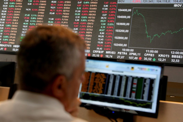 An electronic board showing the graph of the recent fluctuations of market indices is seen as a man works on the floor of Brazil's B3 Stock Exchange in Sao Paulo, Brazil, July 25, 2019. 