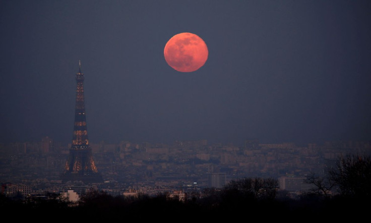 The moon rises behind the Eiffel Tower during a nationwide curfew, from 6 p.m to 6 a.m, due to tighter measures against the spread of the coronavirus disease (COVID-19) in Paris, France, February 27, 2021.
