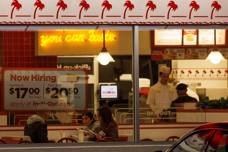 A "Now hiring" sign is displayed on the window of an IN-N-OUT fast food restaurant in Encinitas, California, U.S., May 9, 2022. 