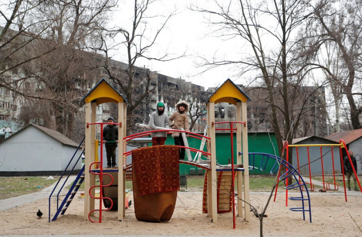 Children play at the playground near an apartment building damaged during Ukraine-Russia conflict in the southern port city of Mariupol, Ukraine April 4, 2022.