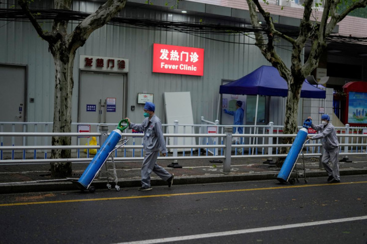 Workers deliver oxygen cylinders outside the fever clinic of a hospital during lockdown amid the coronavirus disease (COVID-19) pandemic, in Shanghai, China April 14, 2022.