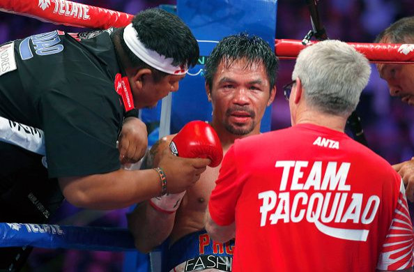 Manny Pacquiao listens to trainers Buboy Fernandez (L) and Freddie Roach during his WBA welterweight title fight against Keith Thurman at the MGM Grand Garden Arena on July 20, 2019 in Las Vegas, Nevada.